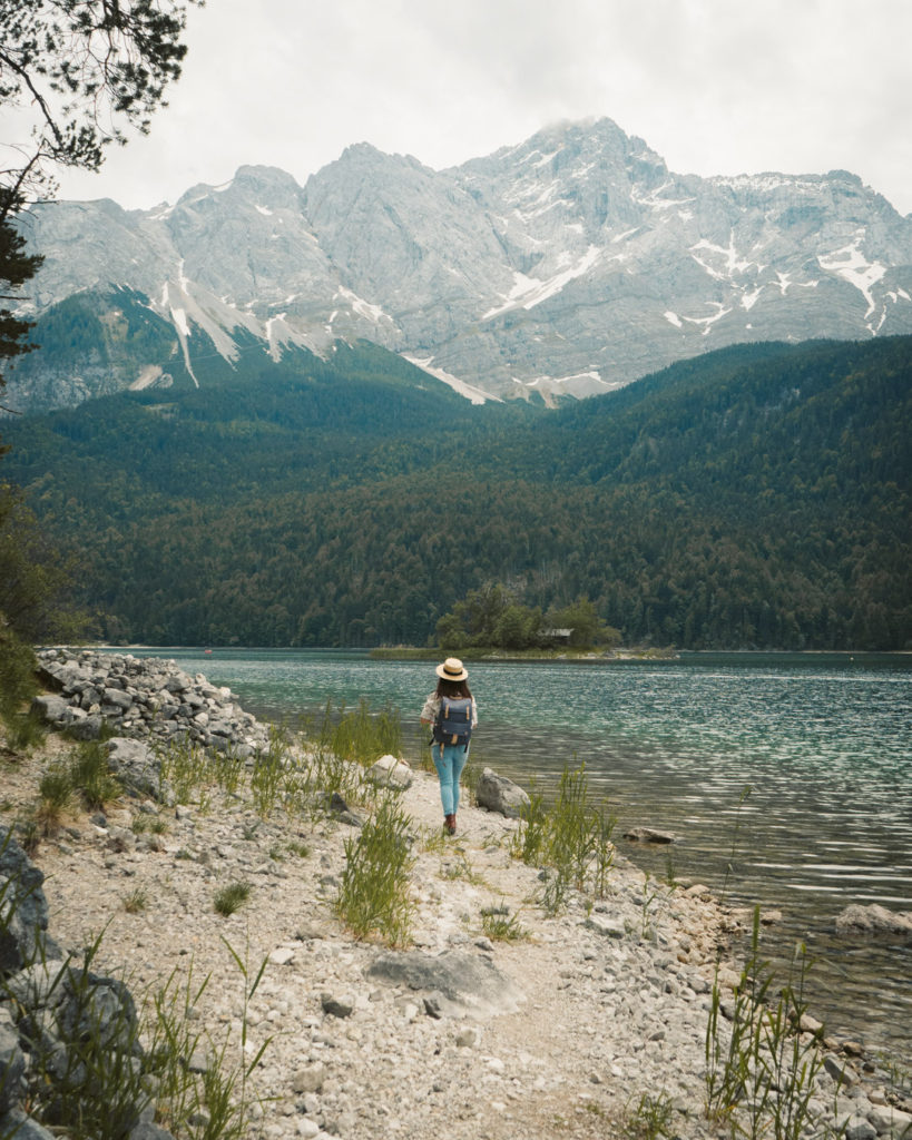 girl in a hat walking along eibsee lake germany