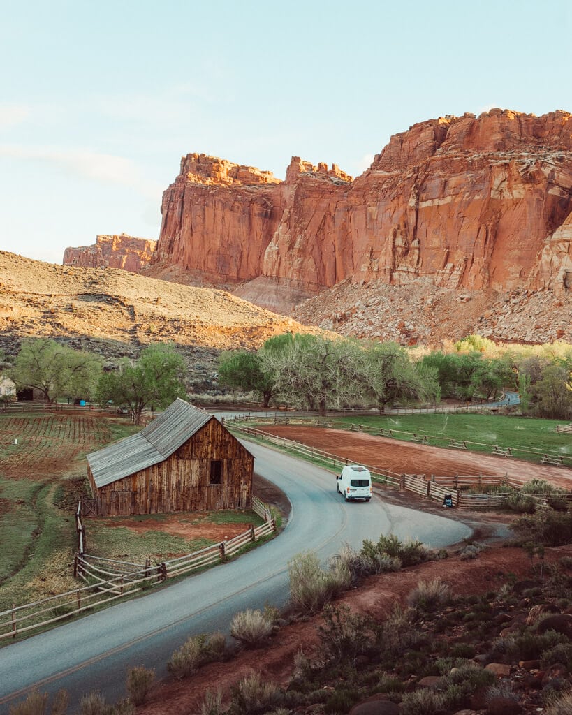 campervan driving past gifford homestead in capitol reef national park during sunrise
