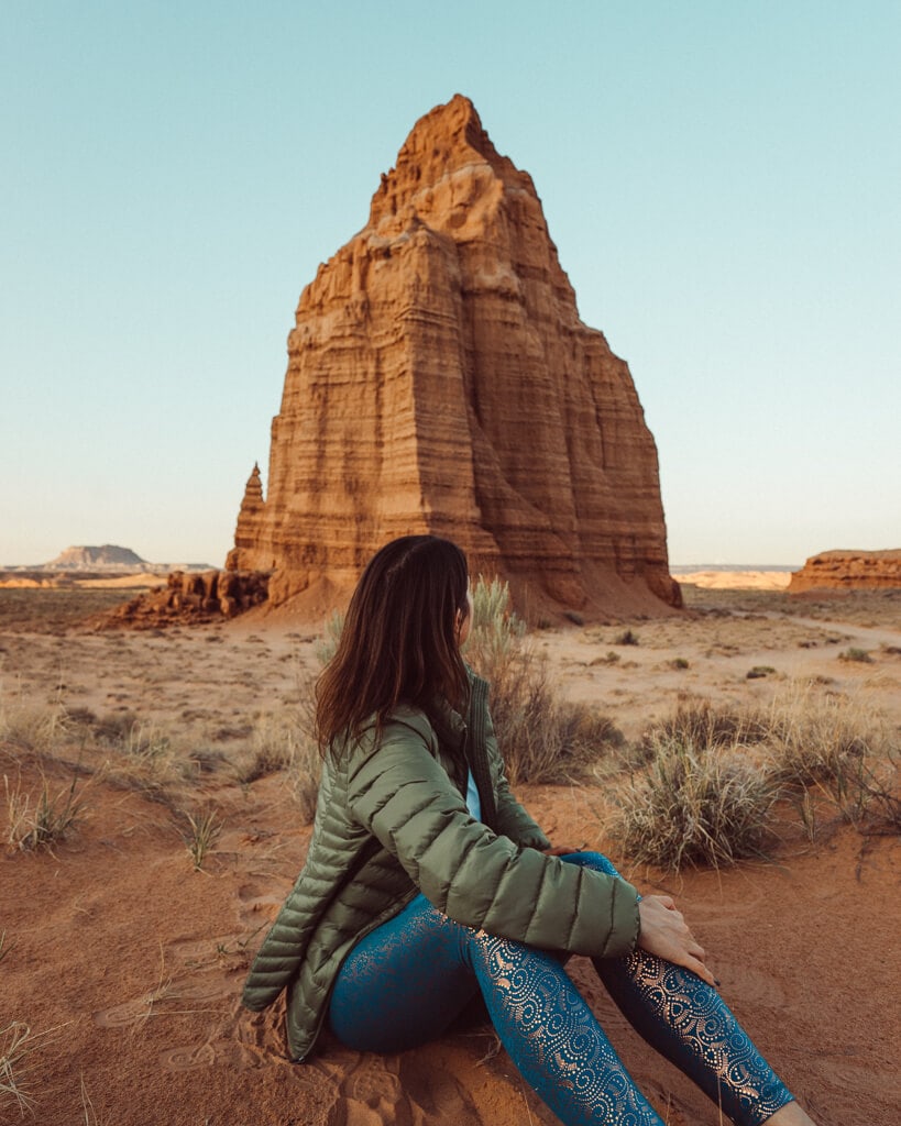 female adventurer admiring the sunset from a temple on cathedral valley road in utah's capitol reef national park