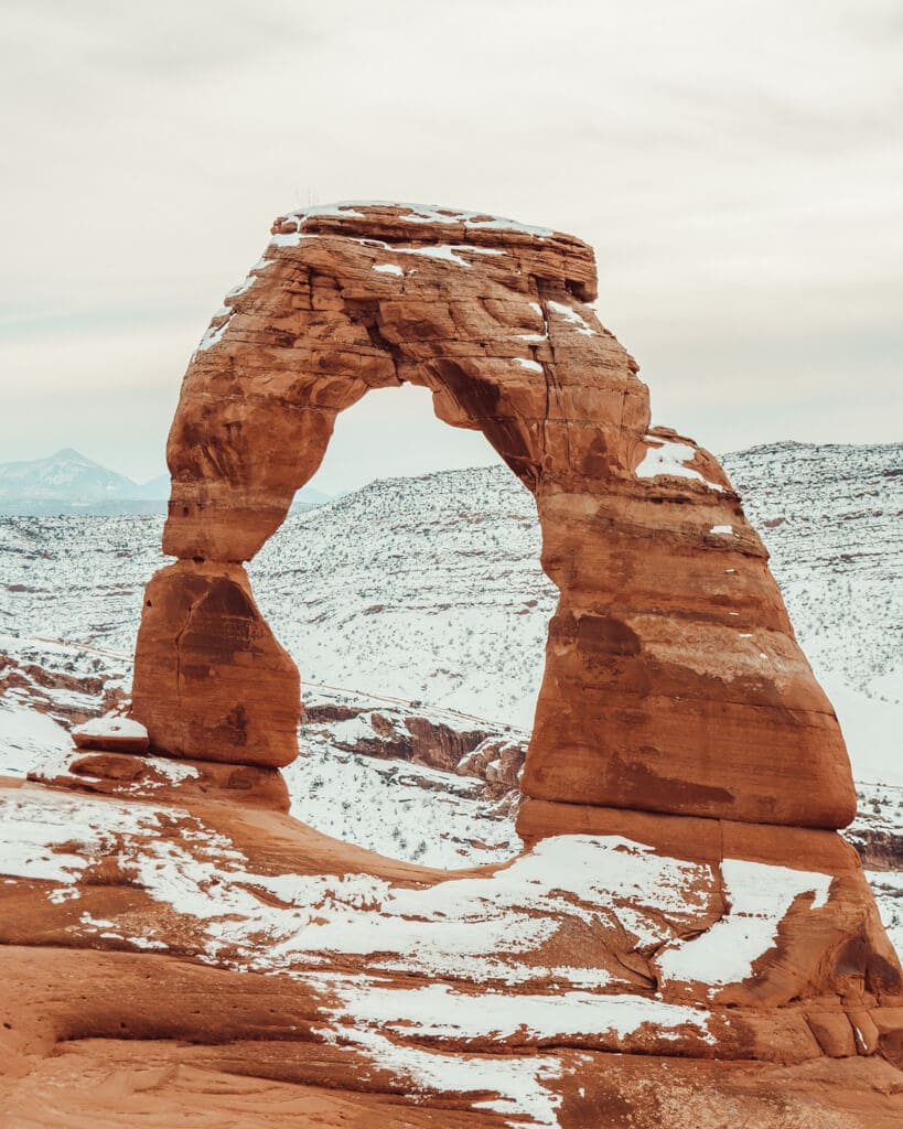 sunrise over the orange delicate arch in arches national park during winter