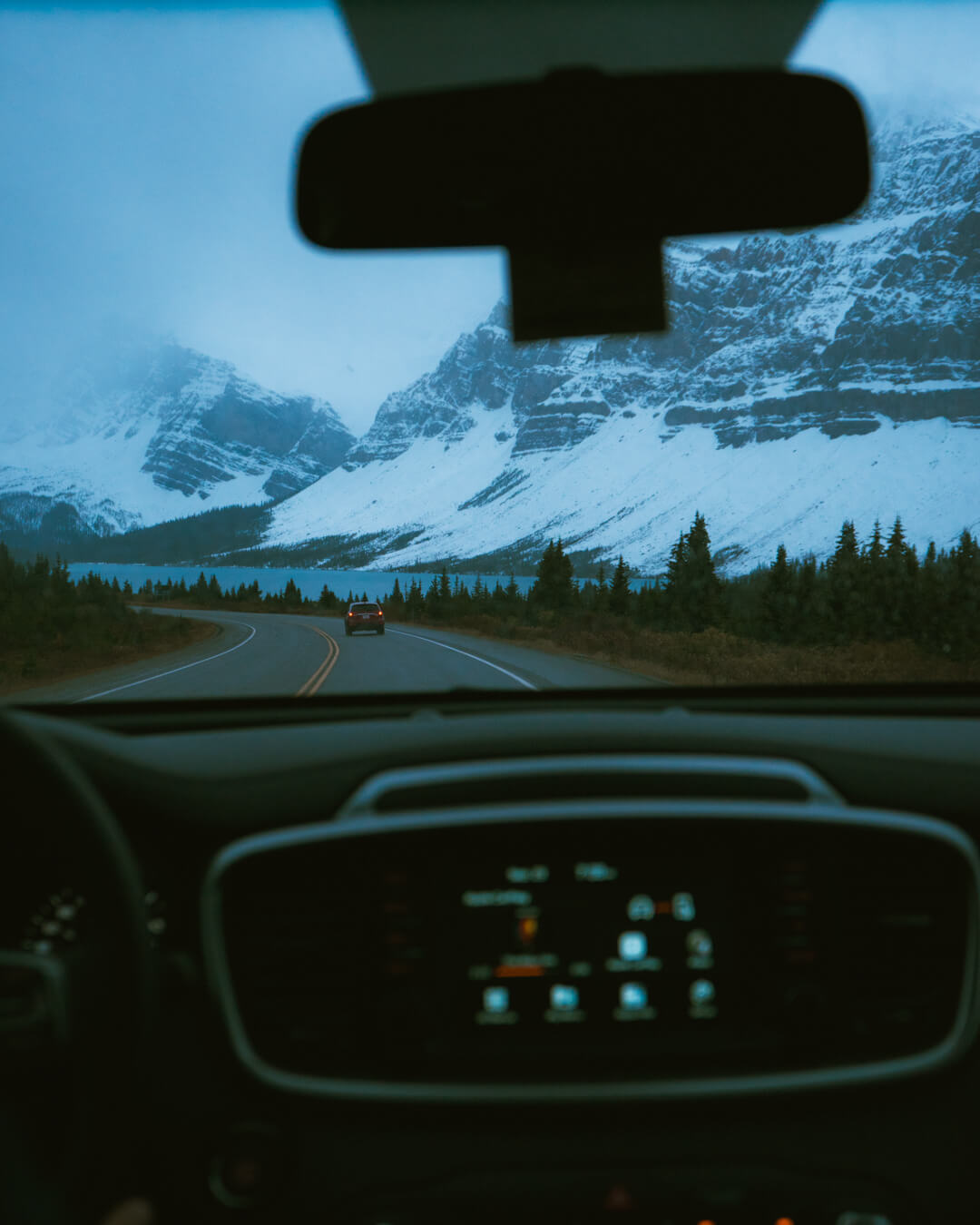 view of inside a car while driving through Banff in winter