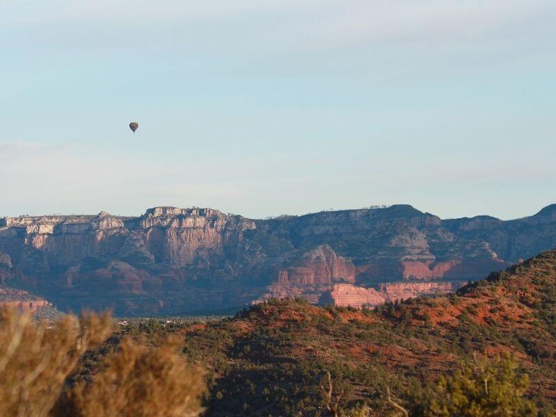Hot air balloon flying over Sedona arizona red rocks