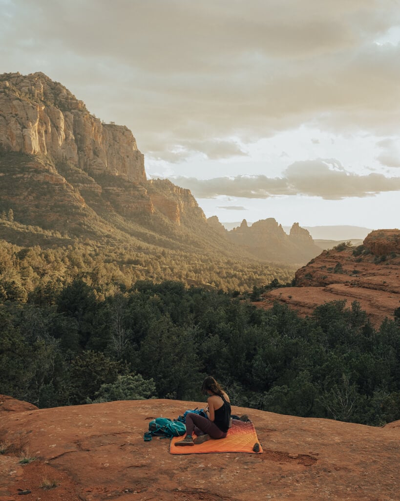 female hiker watching the sunset over munds wagon trail in sedona az