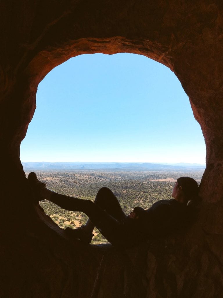girl looking at view from inside Hide Out Cave Sedona AZ