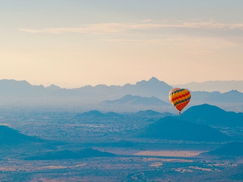 hot air balloon flying over mountains in scottsdale az