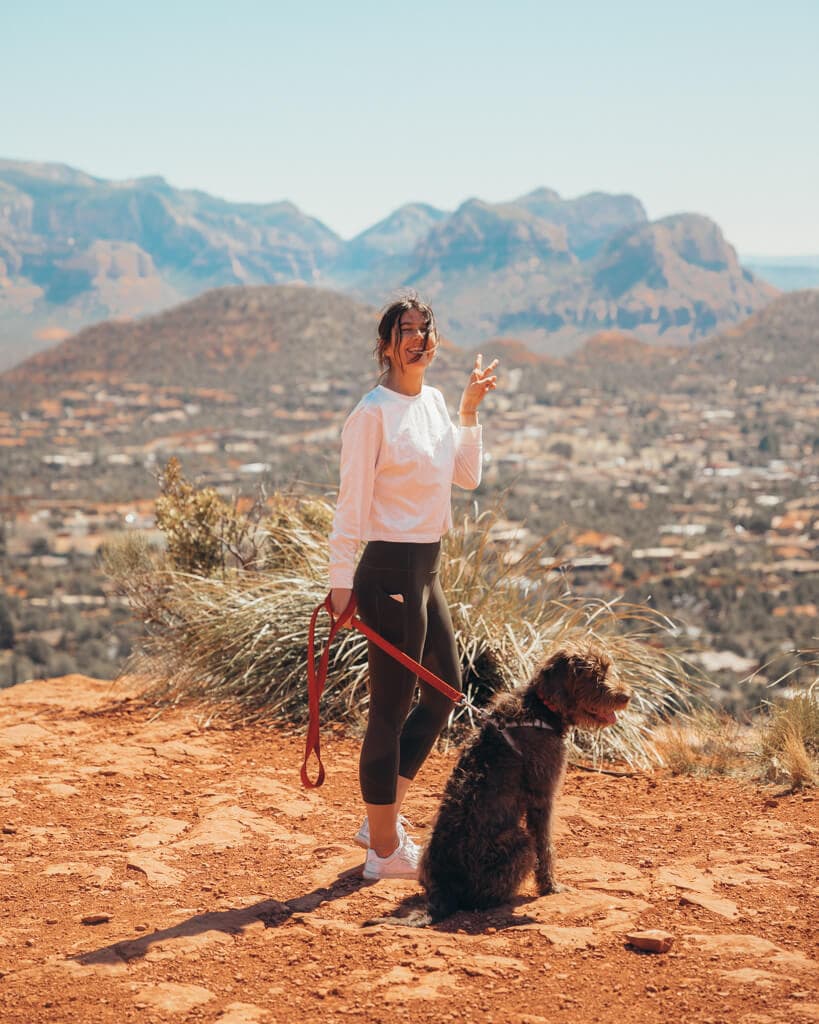 female hiker and dog at the top of sugarloaf mountain in sedona arizona