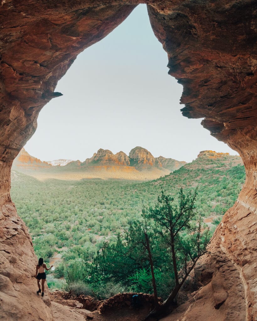 female hiker looking outside the birthing cave sedona