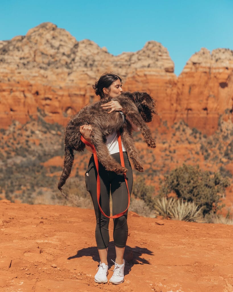 girl and puppy standing at the top of sugarloaf mountain in sedona arizona