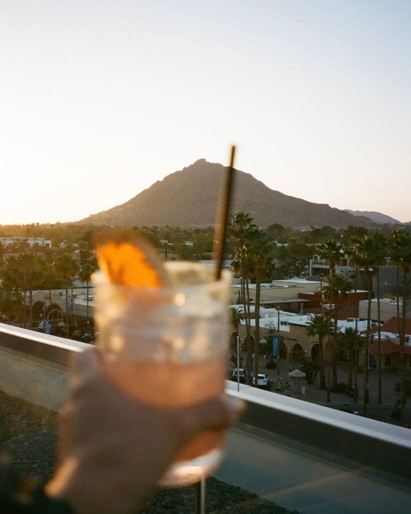 girl holding up a cocktail at camelback mountain in scottsdale az