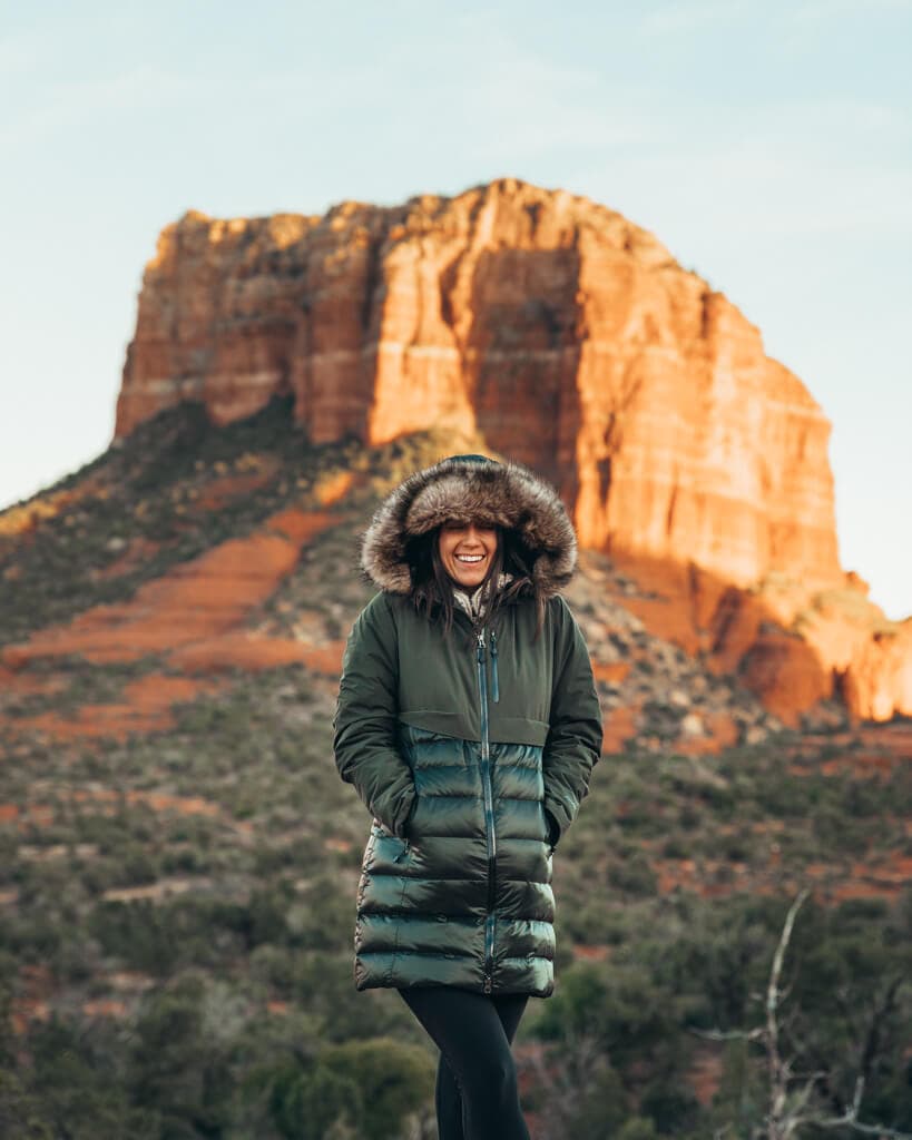 girl in a green coat standing at yavapai vista point in sedona az for sunset