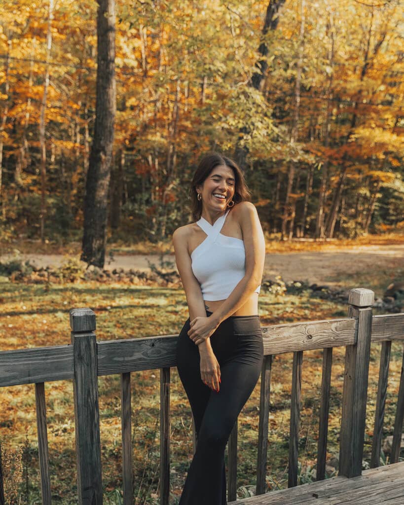 girl standing on a deck overlooking new hampshire fall colors