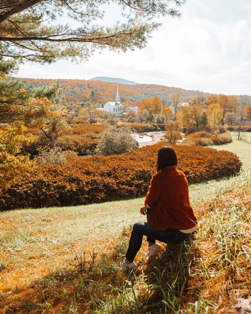 view of a girl wearing a fuzzy jacket, admiring stowe vermont in the fall