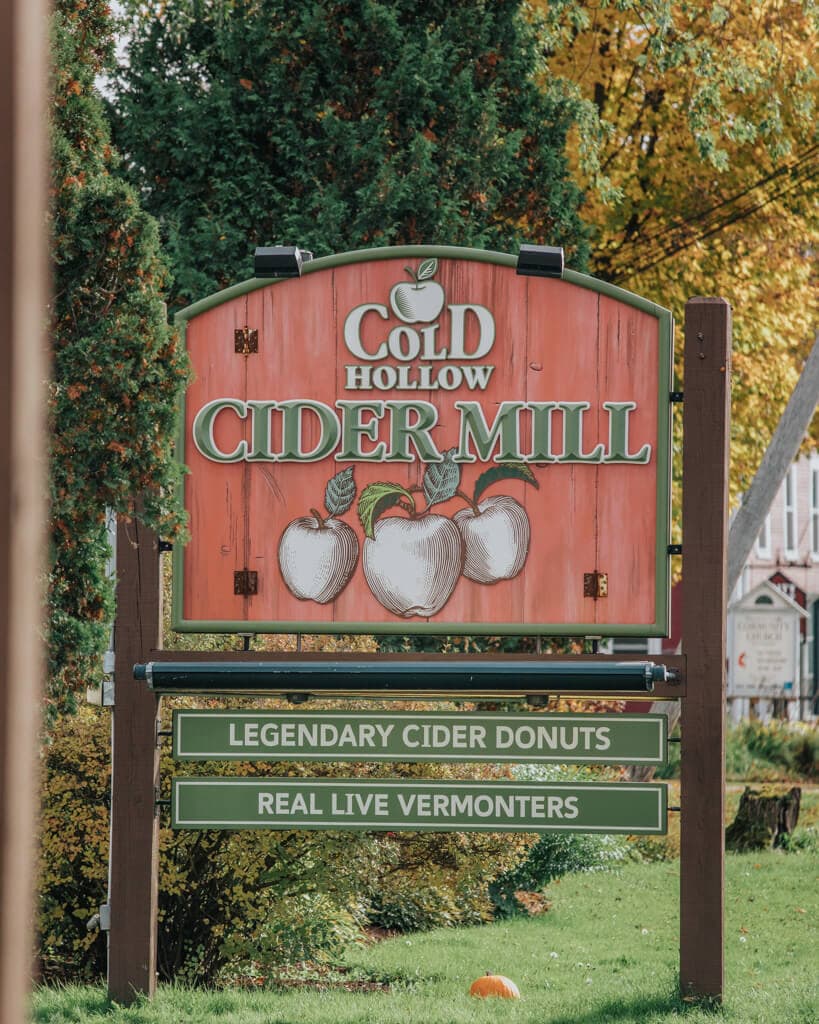 view of the wooden, red sign outside cold hollow cider mill during the fall in stowe vt