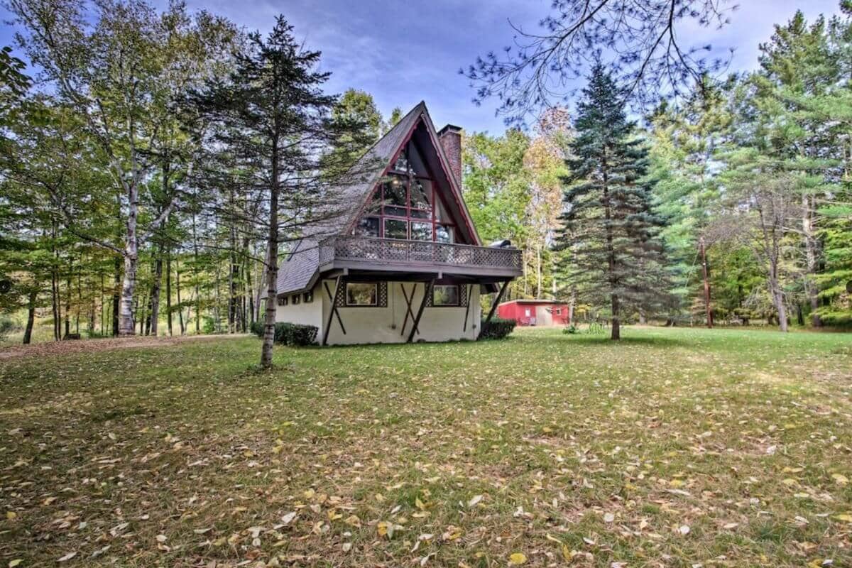 view of an a-frame north conway cabin rental in new hampshire with fall foliage on the ground