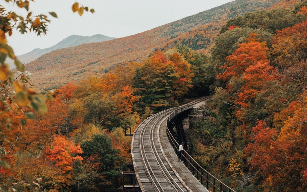 bright orange fall foliage surrounding the conway railway in nh