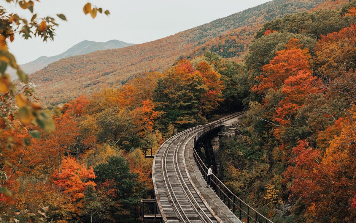 bright orange fall foliage surrounding the conway railway in nh