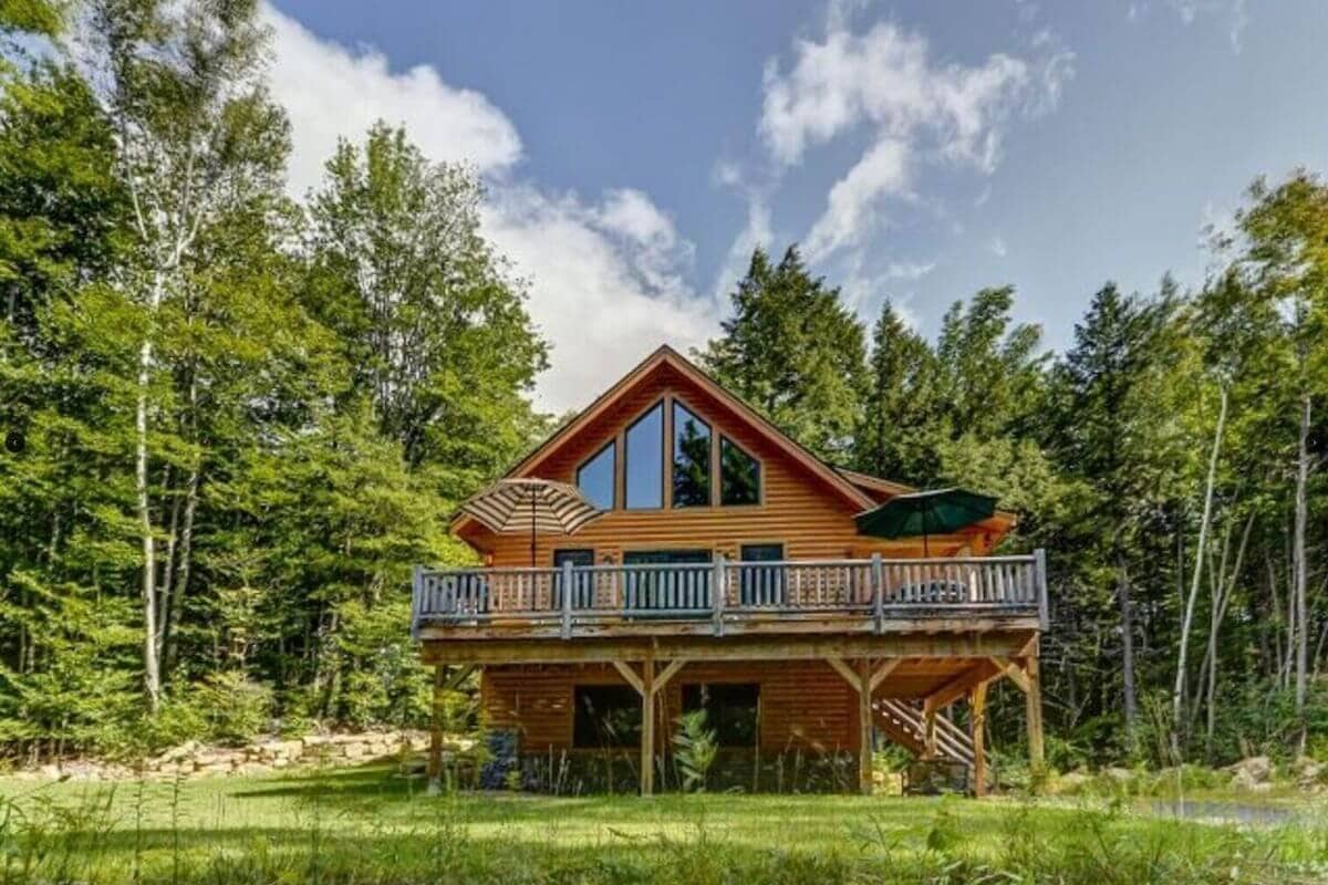 view of a log cabin with a large deck for rent in north conway new hampshire