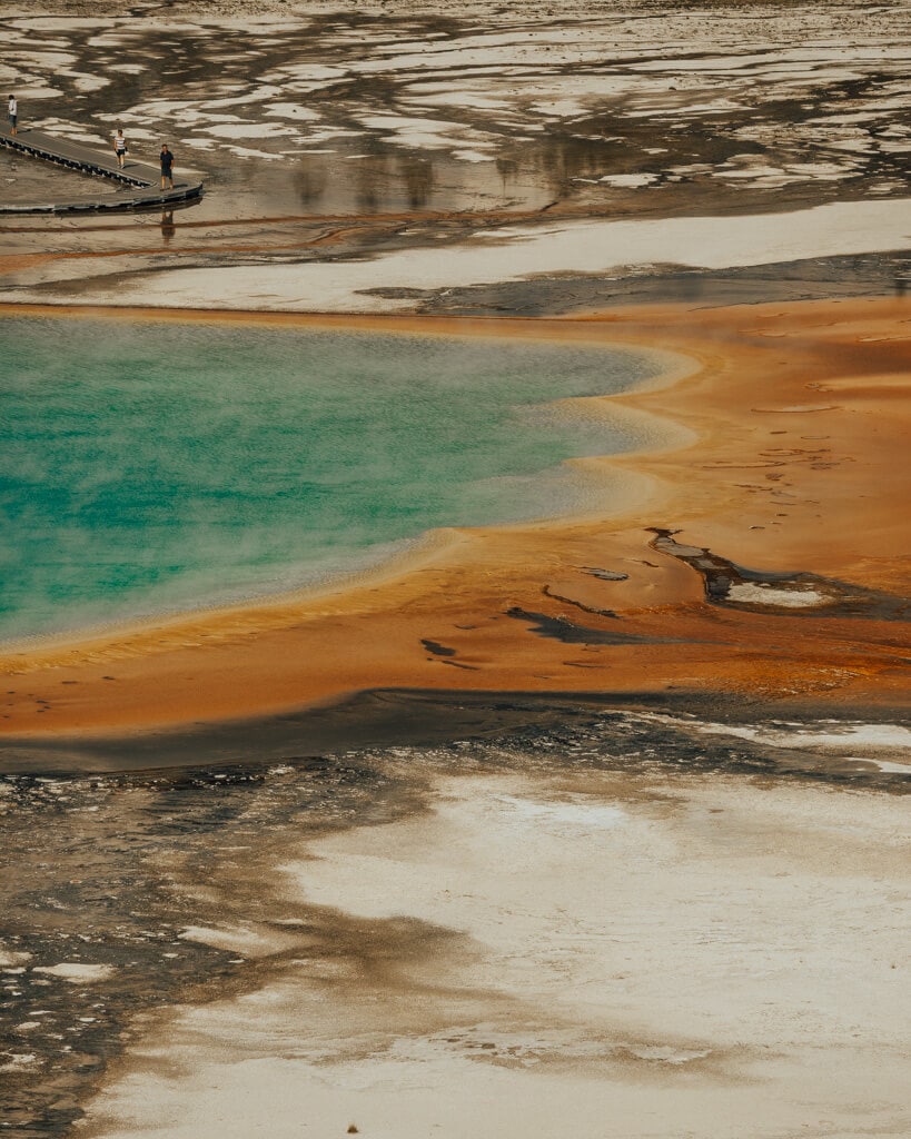 view of the turquoise and orange waters of Grand Prismatic Spring in yellowstone national park