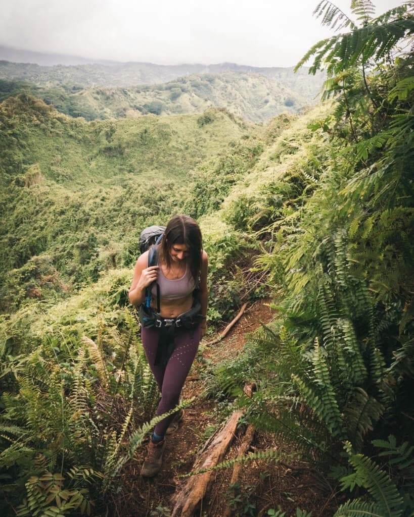 female hiker hiking the bright green Kuilau Ridge Trail in kauai hawaii