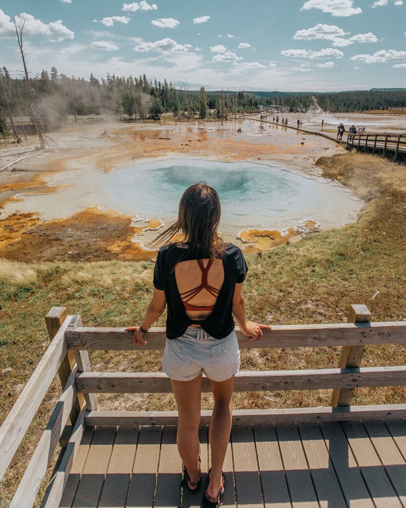 female admiring a thermal pool along fountain paint pot trail in yellowstone national park