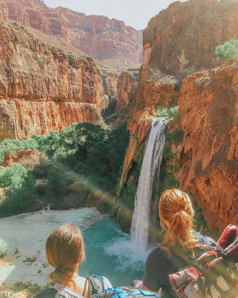 two female hikers looking at havasupai falls in arizona
