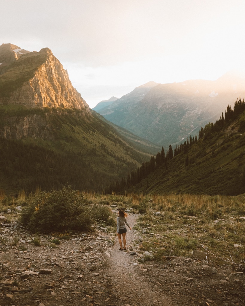 girl walking along big bend viewpoint in glacier national park for sunset
