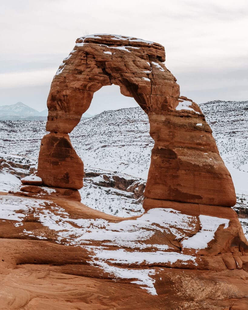 sunrise over the orange delicate arch in arches national park during winter