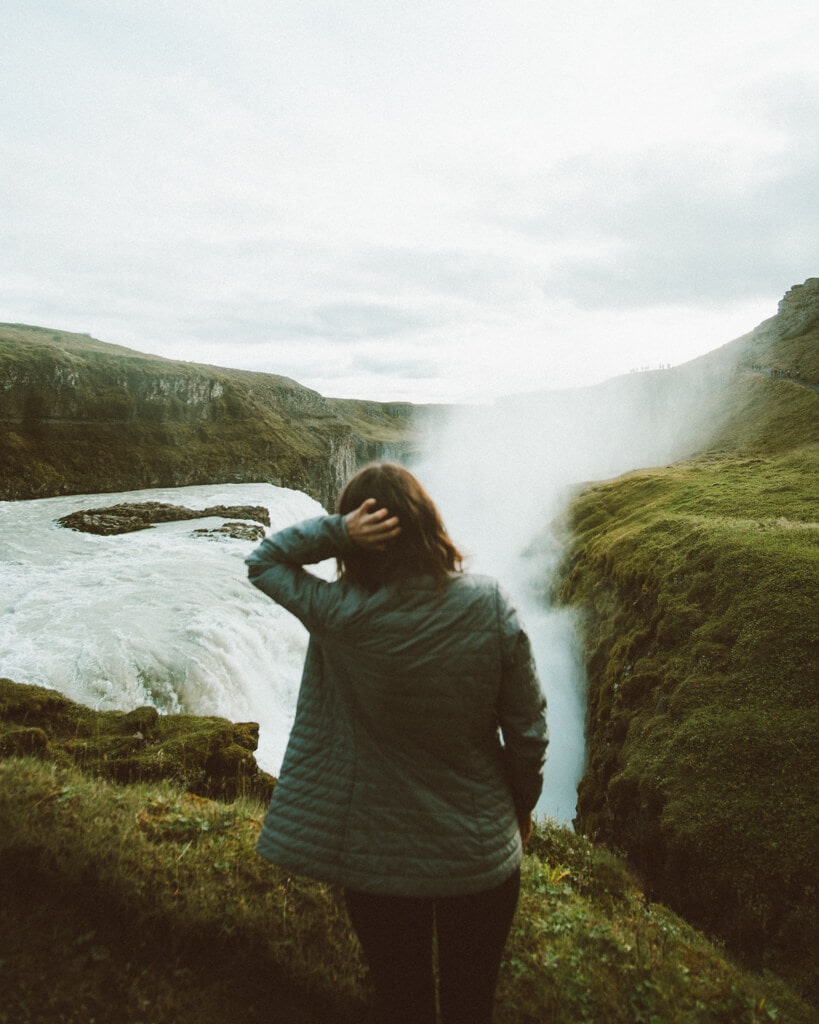female looking out at gullfoss in iceland