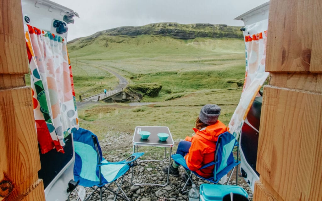 male and female traveler admiring iceland from their camper van