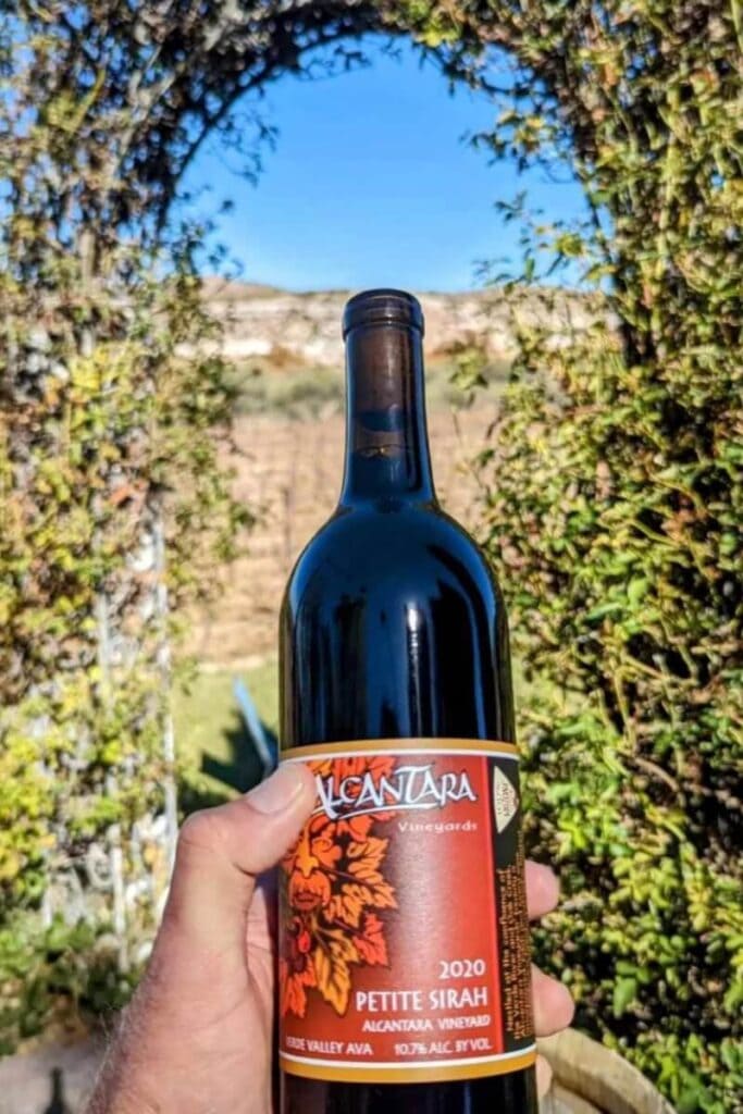 hand holding a wine bottle at Alcantara Vineyards Sedona