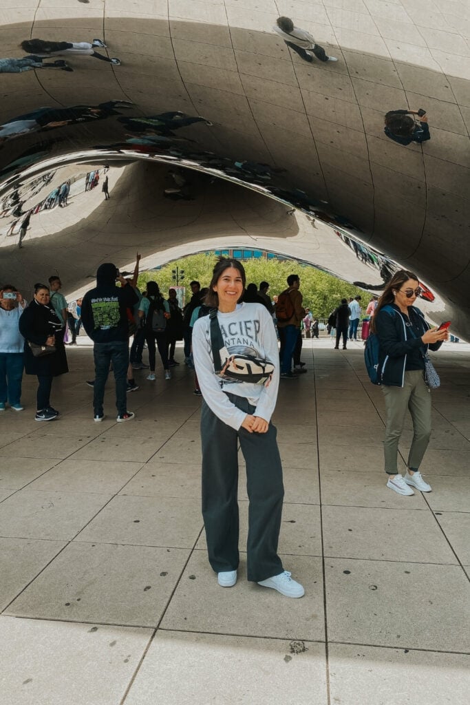 female posing in front of the bean cloudgate millennium park chicago