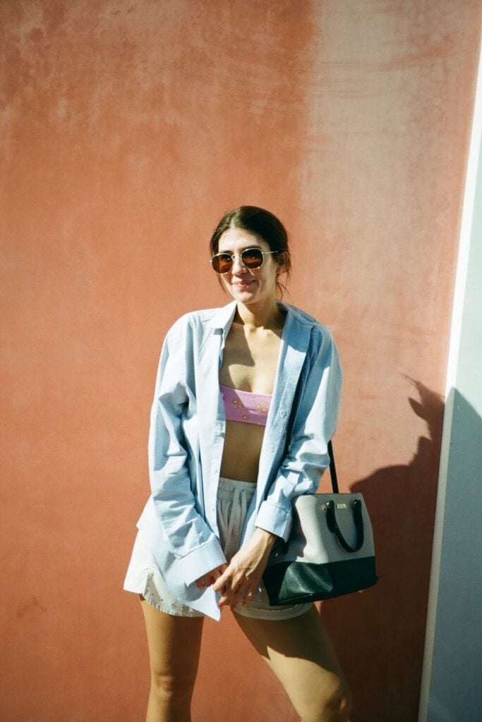 girl standing outside red wall on rosemary beach inn