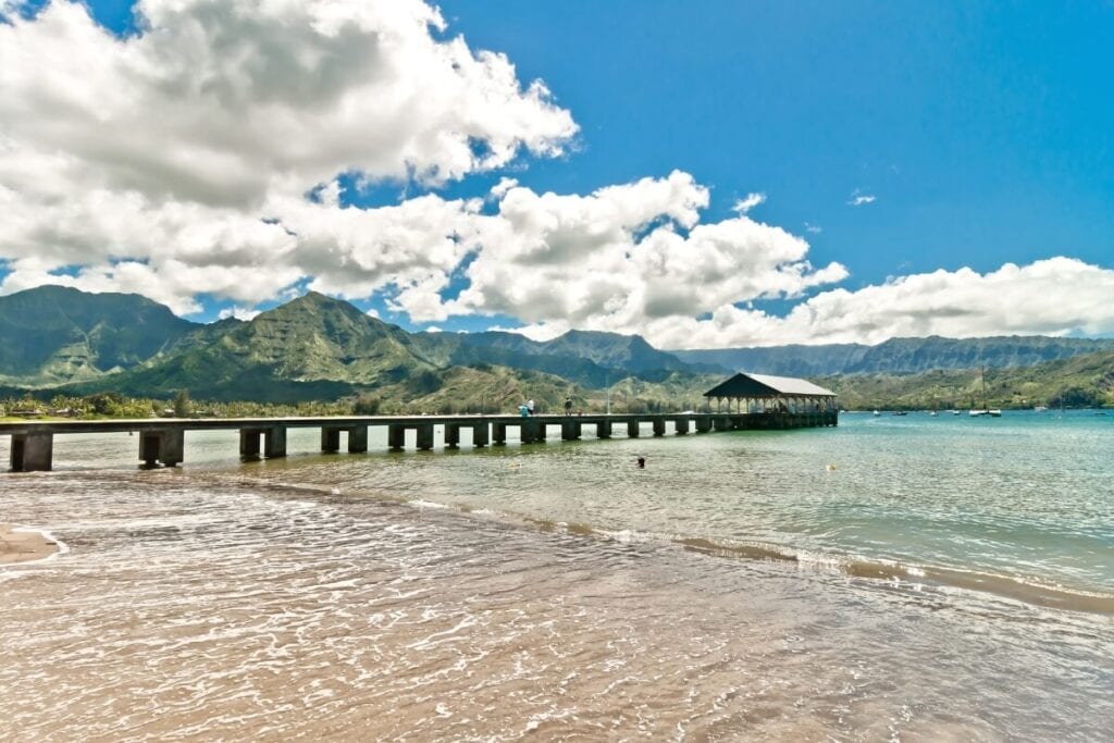 cloudy day over the clear blue waters and boardwalk in hanalei hawaii