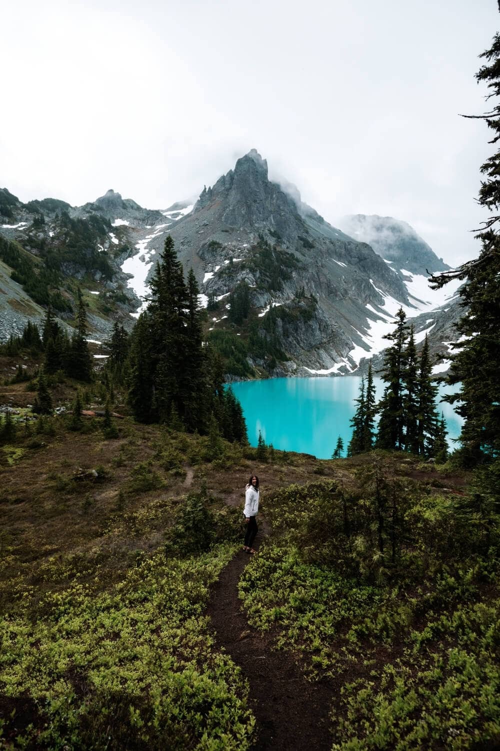 female hiker walking along jade alpine lake washington