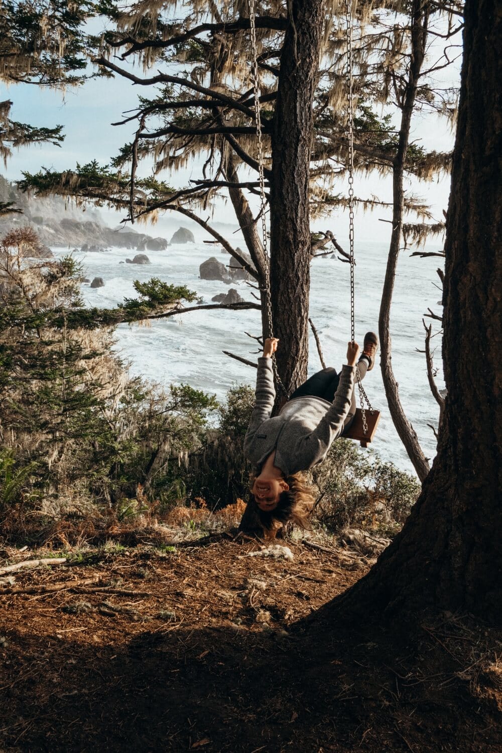 girl on a swing along the california coast in trinidad, ca