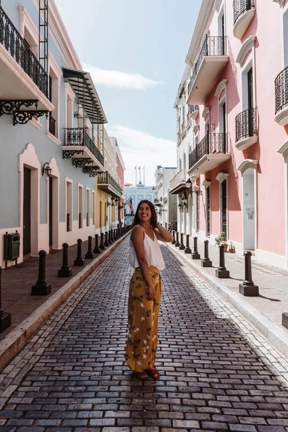 girl in yellow pants taking a picture along calle fortaleza