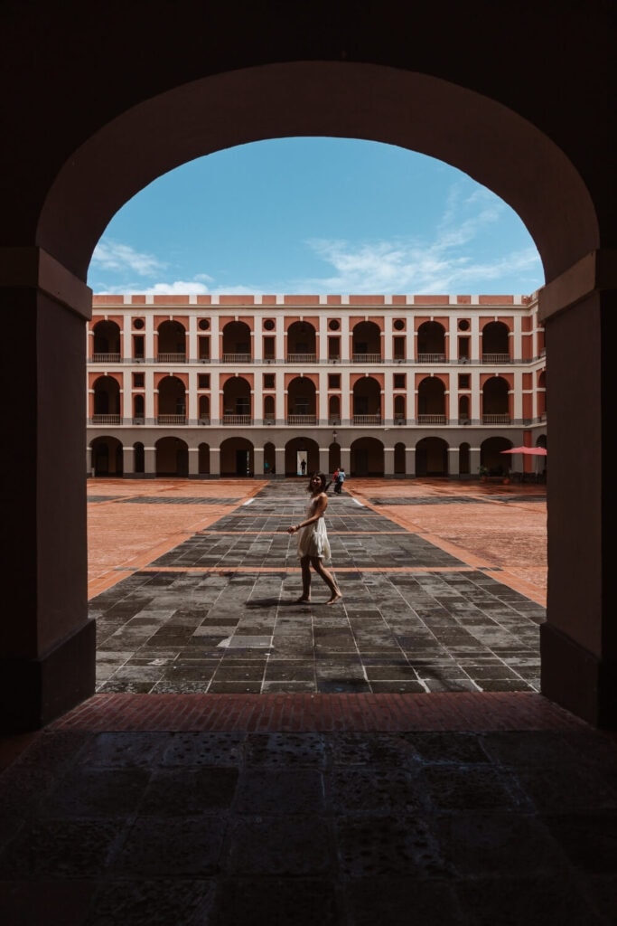 girl n a white dress walking along cuartel de ballaja puerto rico