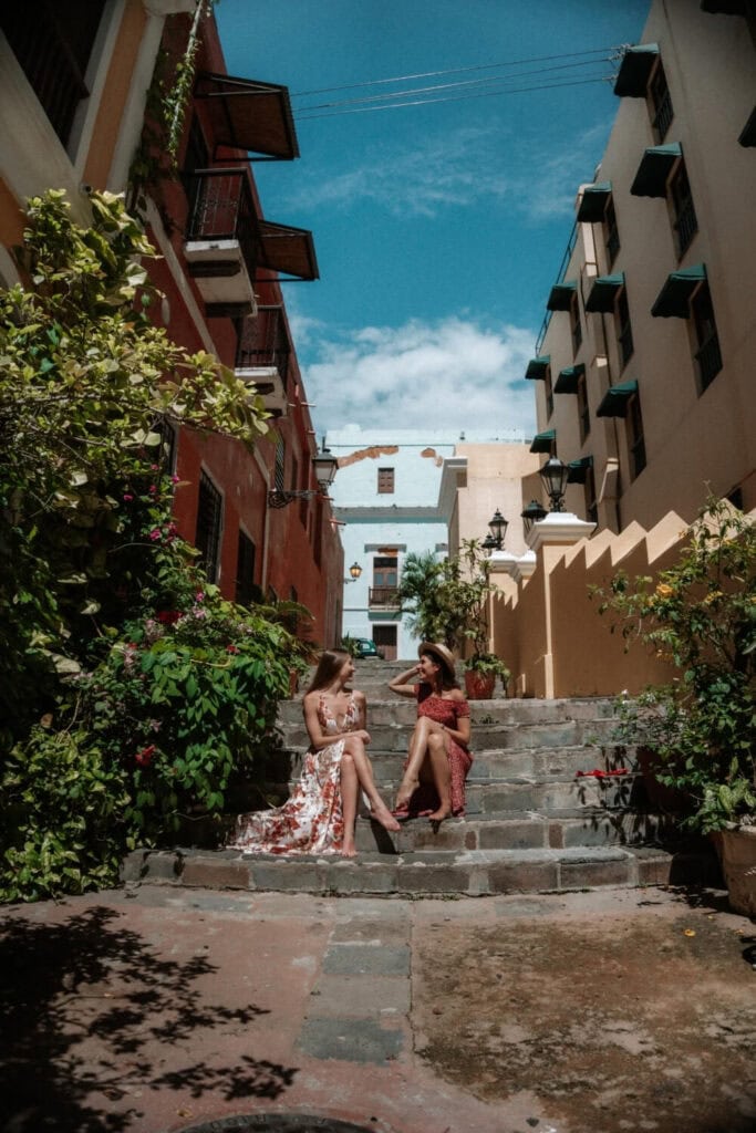 two female travelers sitting on the steps of Hotel El Convento