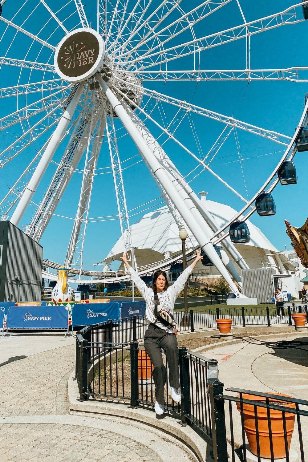 girl standing in front of cantennial wheel in chicago.