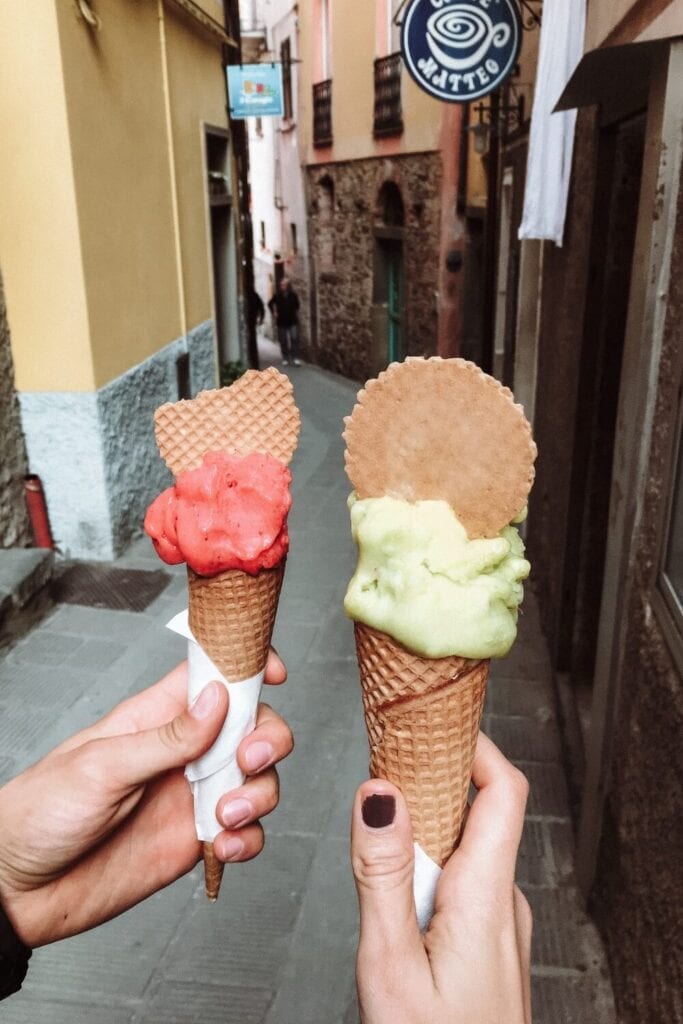 travel couple enjoying pink gelato from corniglia