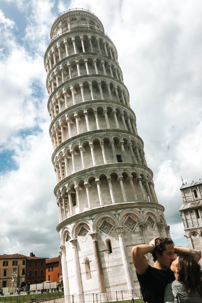 couple travelers standing near the leaning tower of pisa italy